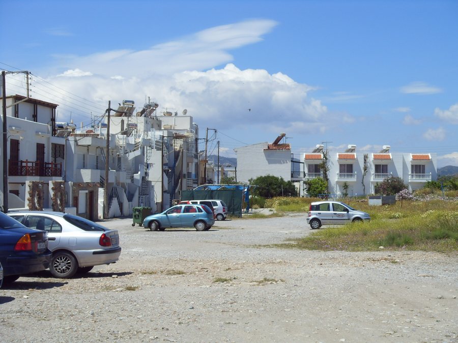 Parkende Autos auf einem Parkplatz neben Gebäuden auf Rhodos