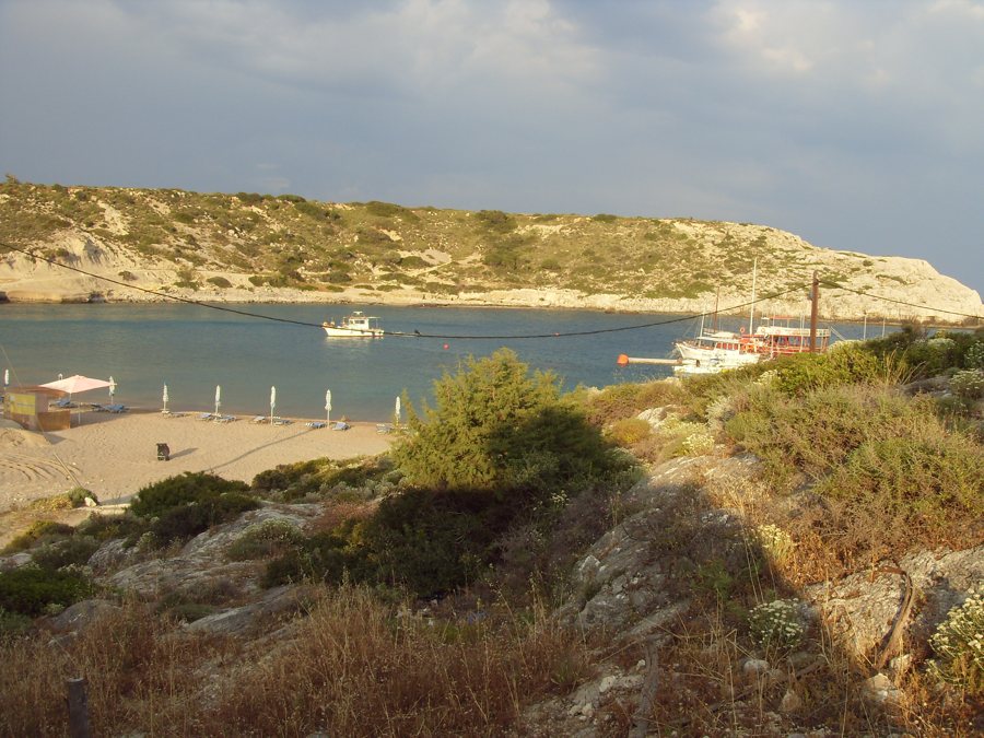 Bucht auf Rhodos mit Booten und felsigem Ufer.