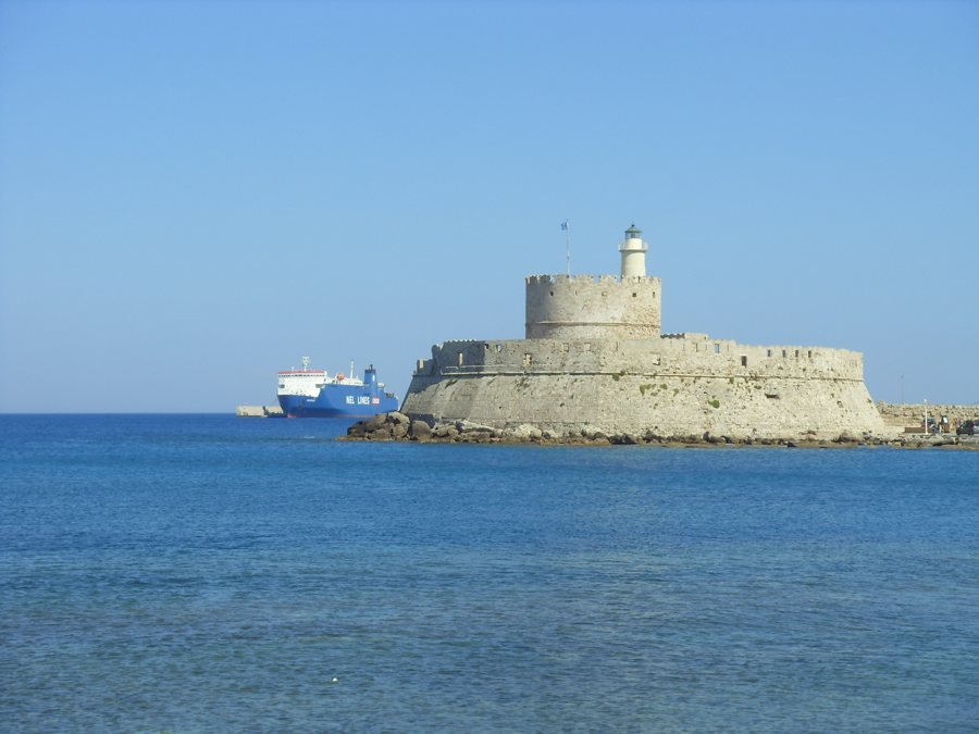 Festung und Leuchtturm von Rhodos mit Fährschiff im Hintergrund