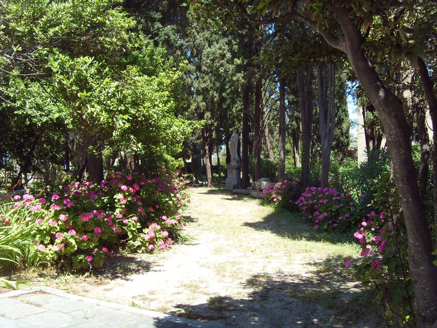 Schattiger Gartenweg mit blühenden Sträuchern in Rhodos-Stadt