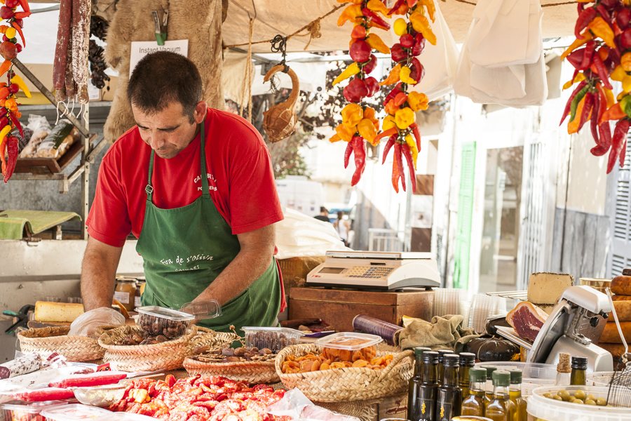 Marktstand mit Oliven, Käse, Schinken und Gemüse