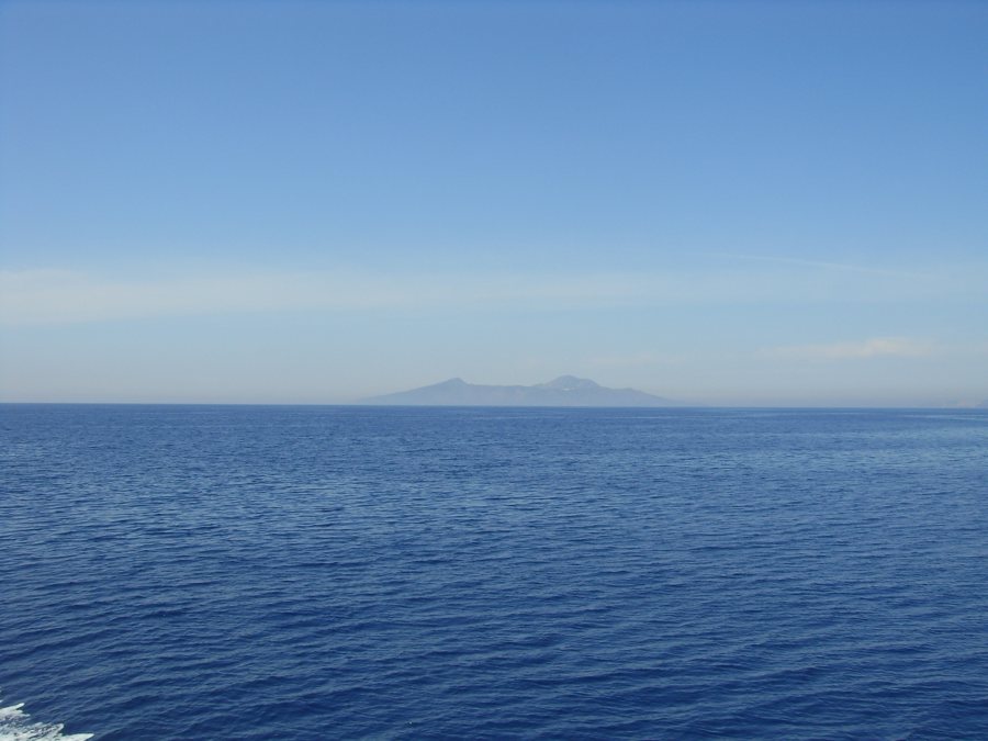 Vulkanische Insel am Horizont über dem Meer