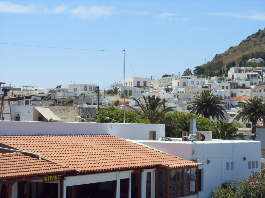 Weiße Häuser und Palmen an einem Hang auf Patmos