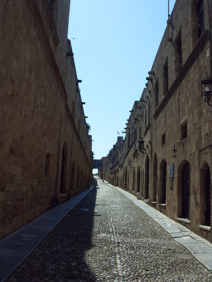 Enge gepflasterte Gasse zwischen historischen Steinhäusern in Rhodos-Stadt.