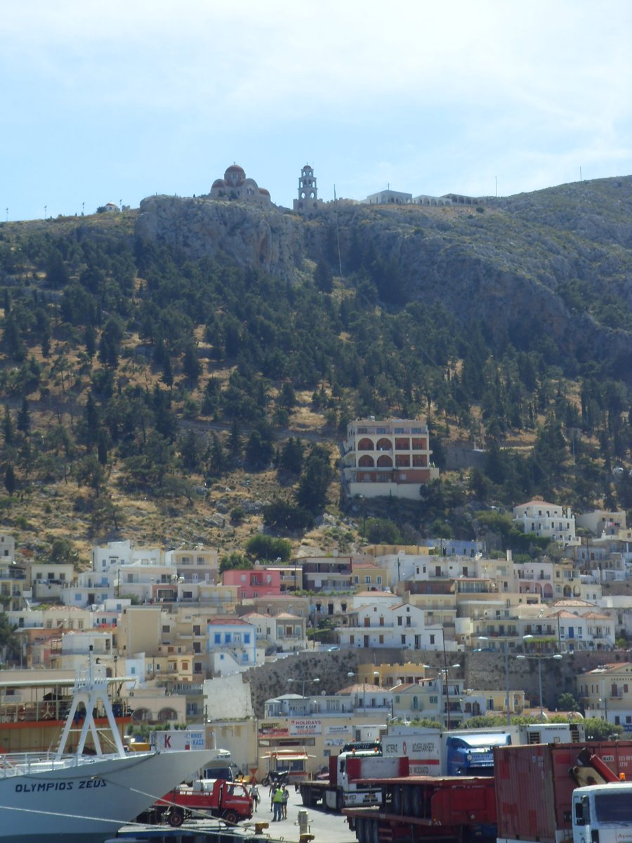 Hügelkirche über dem Hafen und den Häusern von Kalymnos.